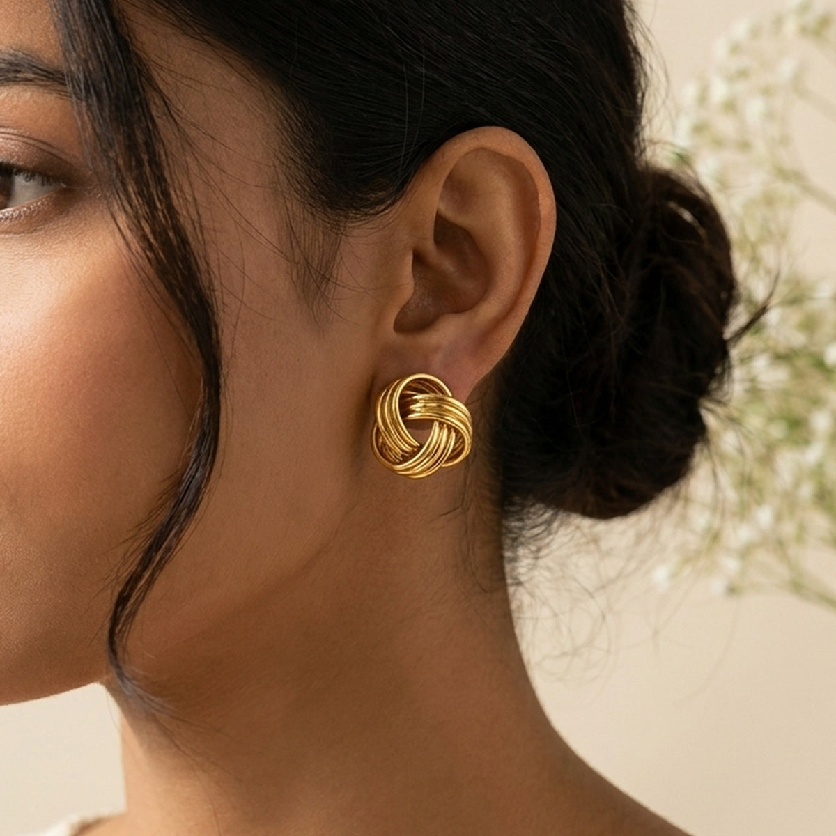 Golden Knot Stud Earrings worn on the ear, handmade by Dream Karigiri