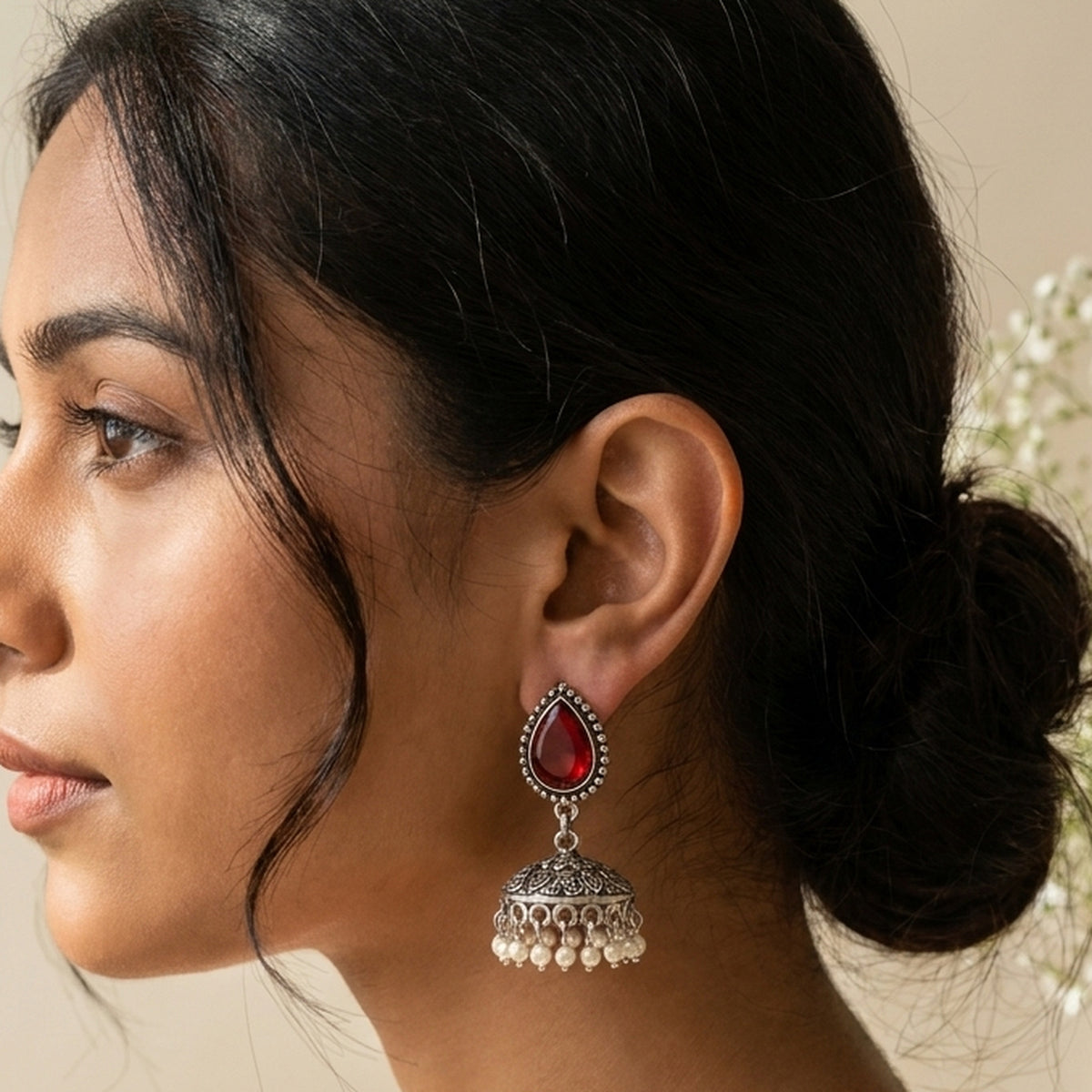 Sindoor Red Teardrop Jhumkas worn on the ear, handmade by Dream Karigiri