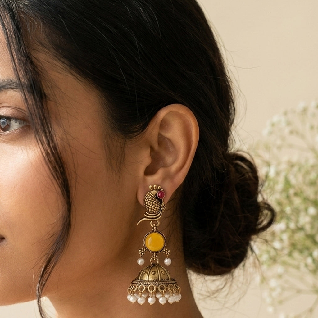 Oxidized Golden Peacock Jhumka - Yellow worn on the ear, handmade by Dream Karigiri